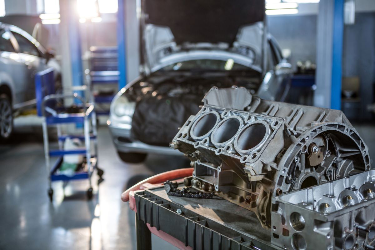 A car engine is being worked on in an automotive franchise garage.